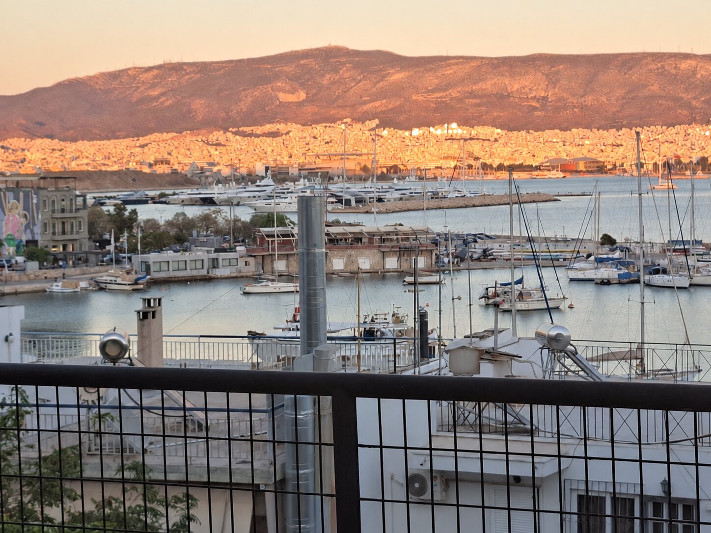 Sunset over Mikrolimano marina and the hills
